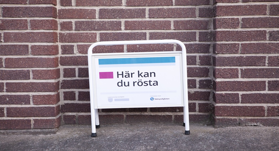 Skylt utanför röstningslokal med texten: här kan du rösta.