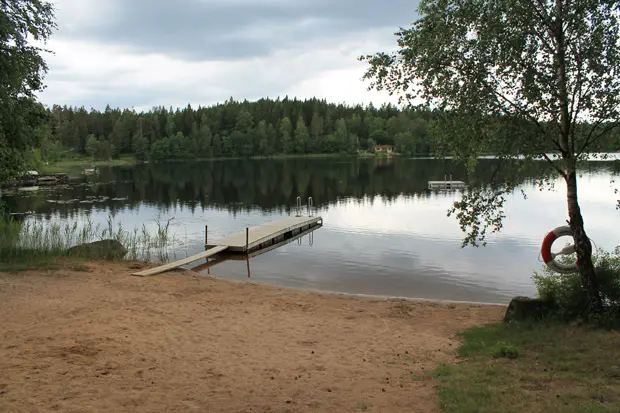 Badsjö med strand och brygga i nedåtlut