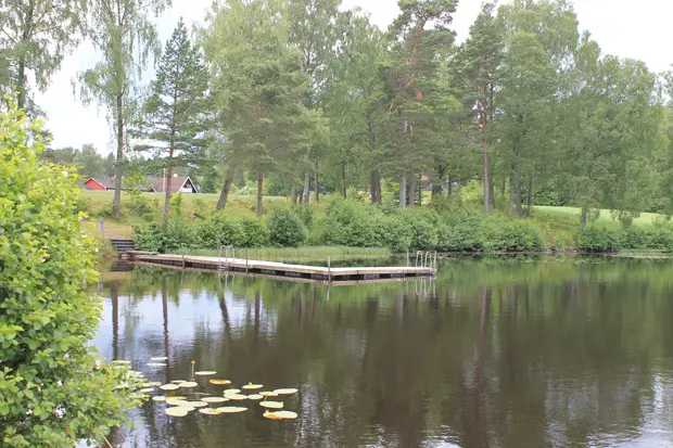 Badsjö en brygga med en liten strand med gräs och sand