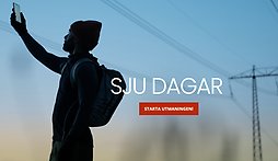 kille som håller upp en mobiltelefon 