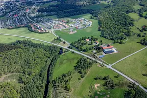 Flygfoto över Säveån, skog och åkrar, Algutstorps kyrka och Algutstorps bostadsområde 